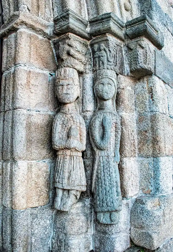 Foto primer plano esculturas estilo románico portada iglesia Santa María del Azogue en Puebla de Sanabria, España